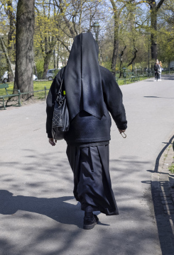 A nun walking down the sidewalk