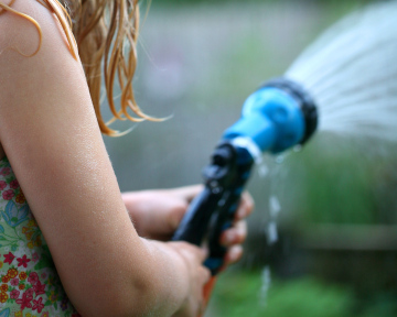 Water in the garden, watering, sprinkler in hand