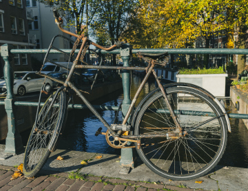 Old bicycle in Amsterdam pinned to the railing stock photo