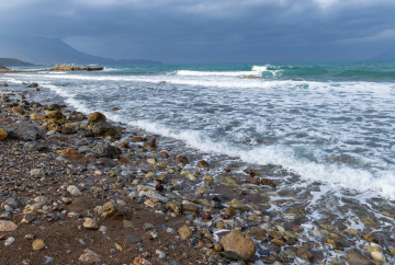 Pebble beach and waves in the sea