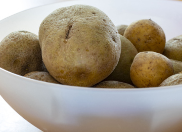 Raw Potatoes In A White Bowl