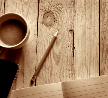 Pencil and coffee on a wooden plank