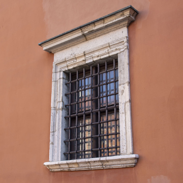 An antique window with an iron grille