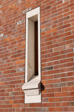 Narrow window in the brick wall of the building