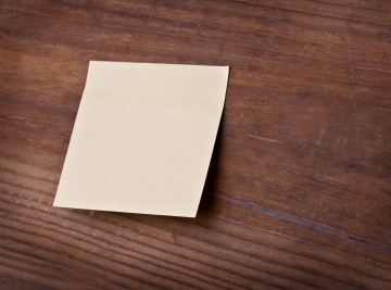 Yellow Sticky Note On A Wooden Board