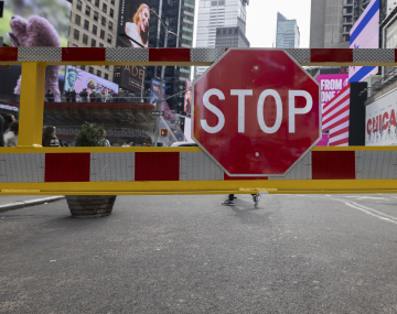 Stop sign, Manhattan and illuminated advertisements in the background