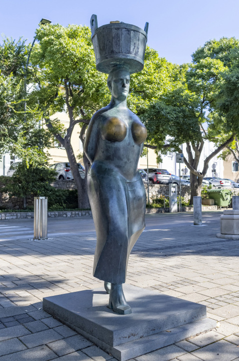 Woman with a dish on her head, statue, sculpture city of Krk, Croatia