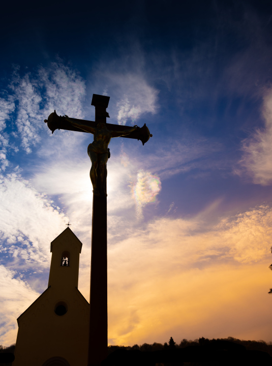 The chapel and the cross against the background of the evening sky