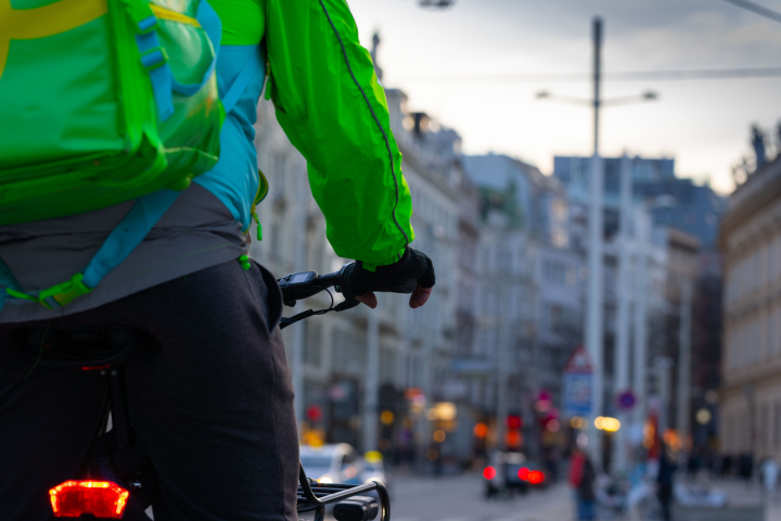 Bicycle courier waiting for the traffic lights to change at an intersection.