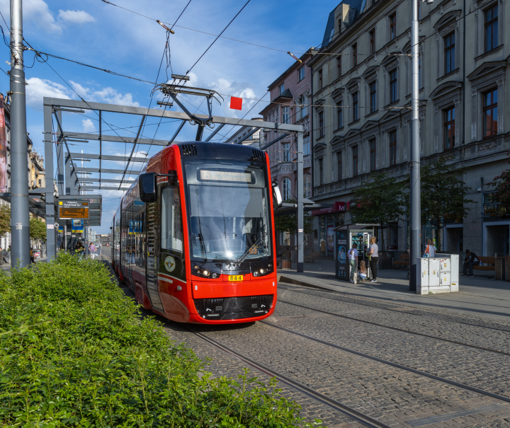 Red tram at the stop.
